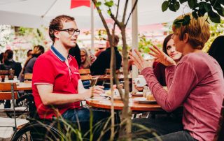 Rollstuhlfahrer mit zwei Frauen im Café © visitBerlin, Foto: Andi Weiland | Gesellschaftsbilder.de