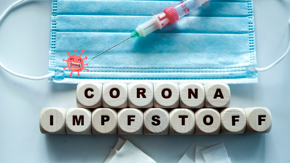 auf weißem Tisch liegen Würfel mitz dem Schriftzug Corona Impfstoffe, eine Maske und eine Spritze mit weindendem Coronavirus, Credit: Canva
